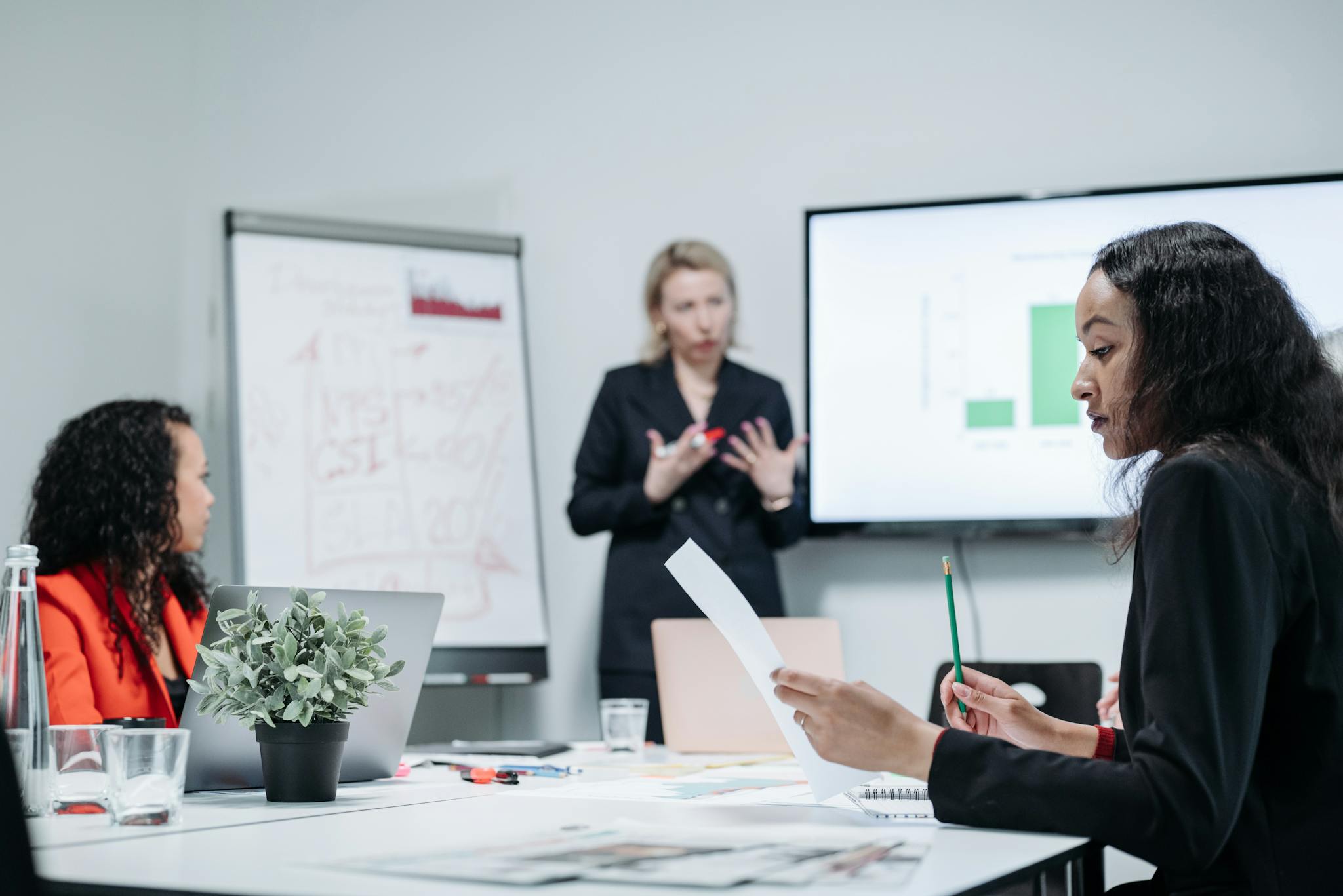 Focused businesswomen collaborating in a modern office setting.